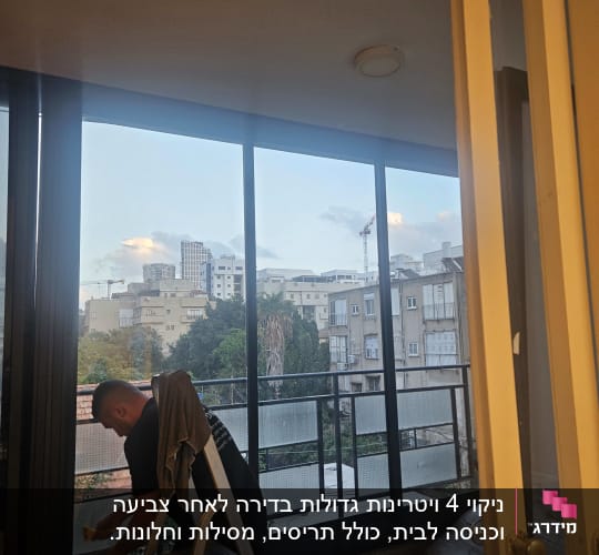 אדם מנקה חלון עם סולם ודלי